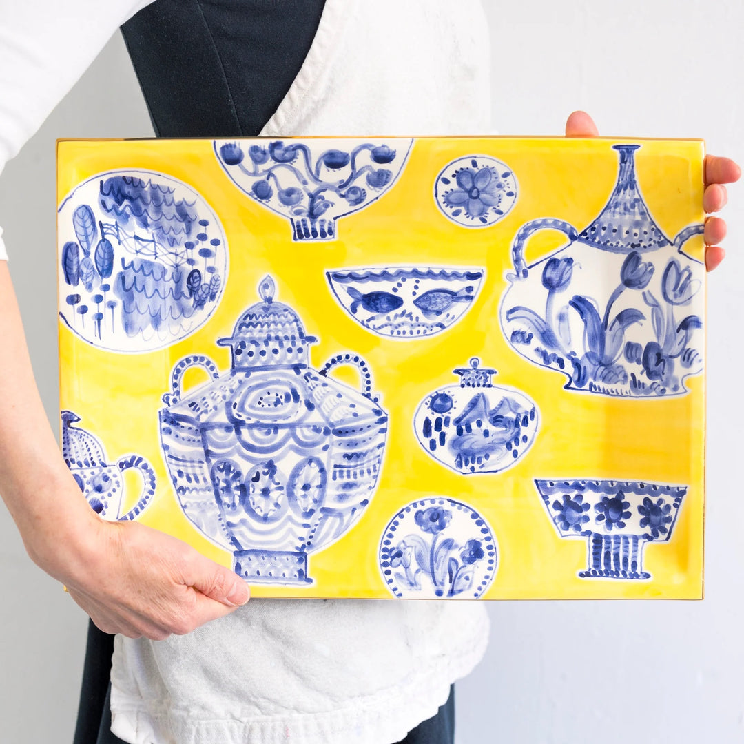 Bright yellow hand painted tray with blue and white vases and china pin it and gold edging.