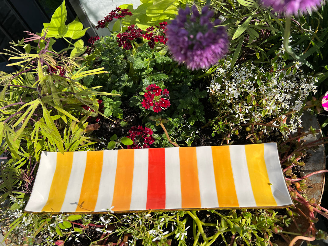 Hand painted tray with red, orange, and yellow stripes and gold edging.