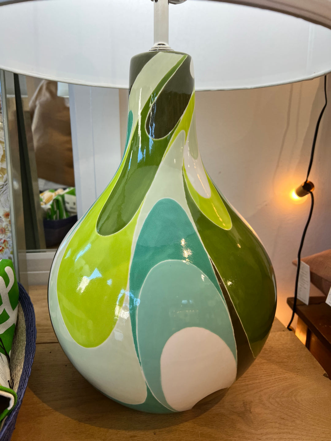A large ceramic lamp with hand painted blue, green and white swirls.