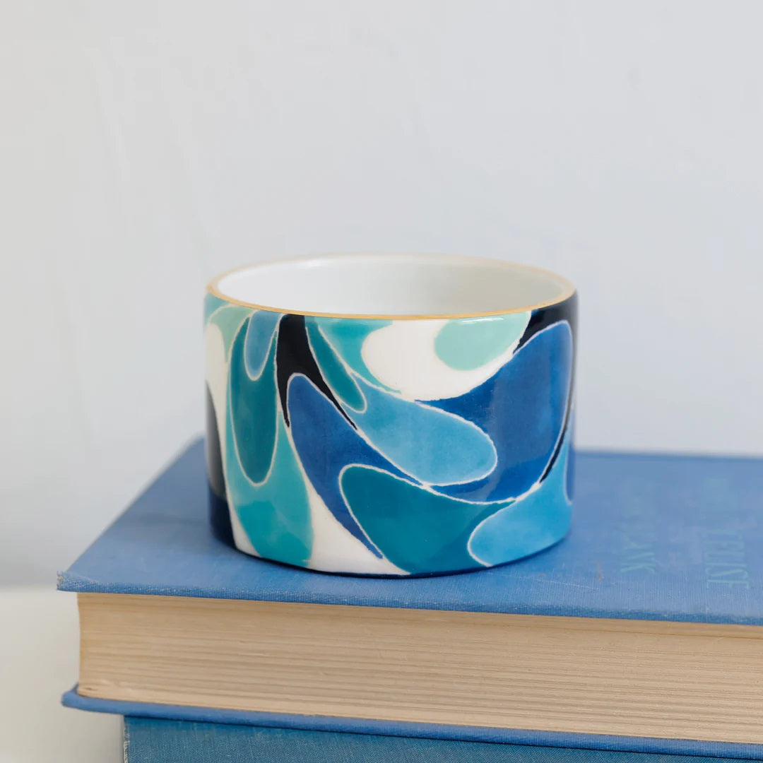 Hand painted ramekin with blue, green and white swirls and gold edging.