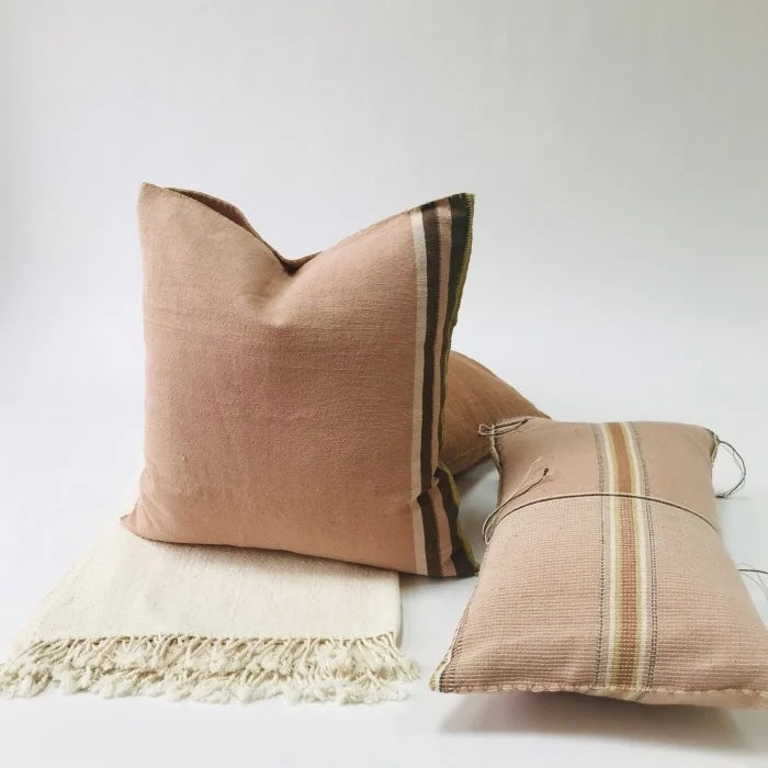 Large dusty pink woven pillows with pink and brown stripes.