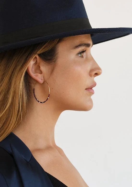 A woman's profile shows a large beaded hoop earring.