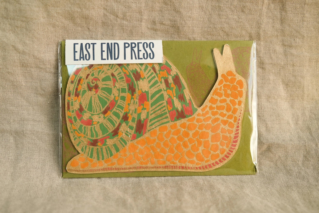 A greeting card shaped like a slug or snail with a colorful shell and matching green envelope.