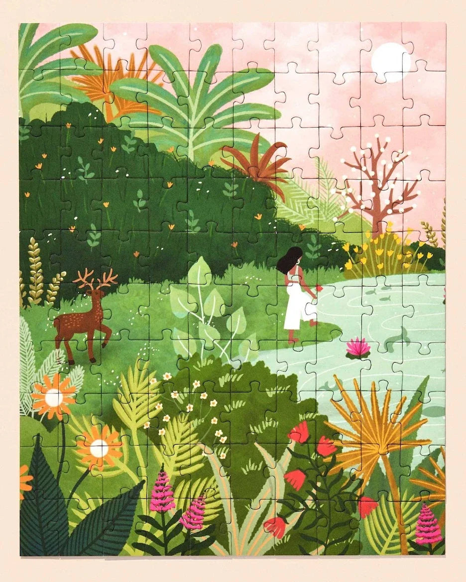 A complete puzzle with lush forest, flowers with a deer and a woman dressed in white by a light blue lake.