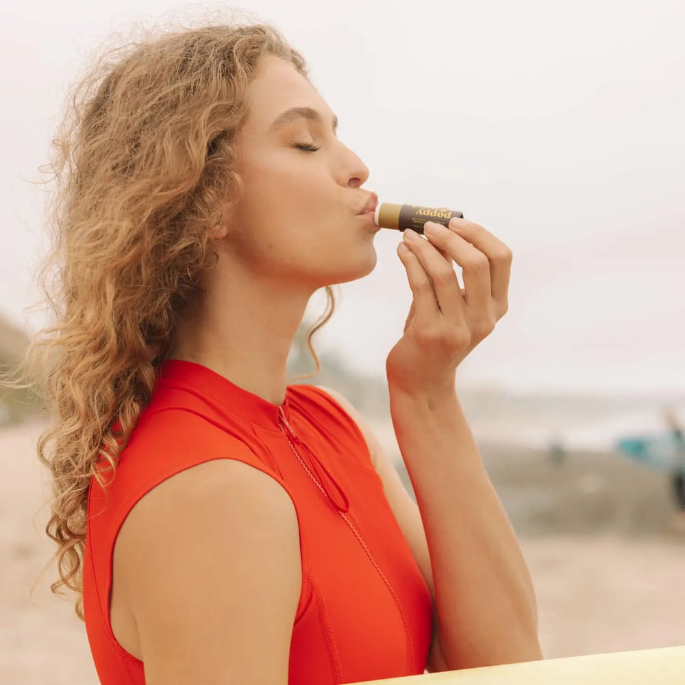 A lady applies Retro Surf Midnight Mint Chapstick