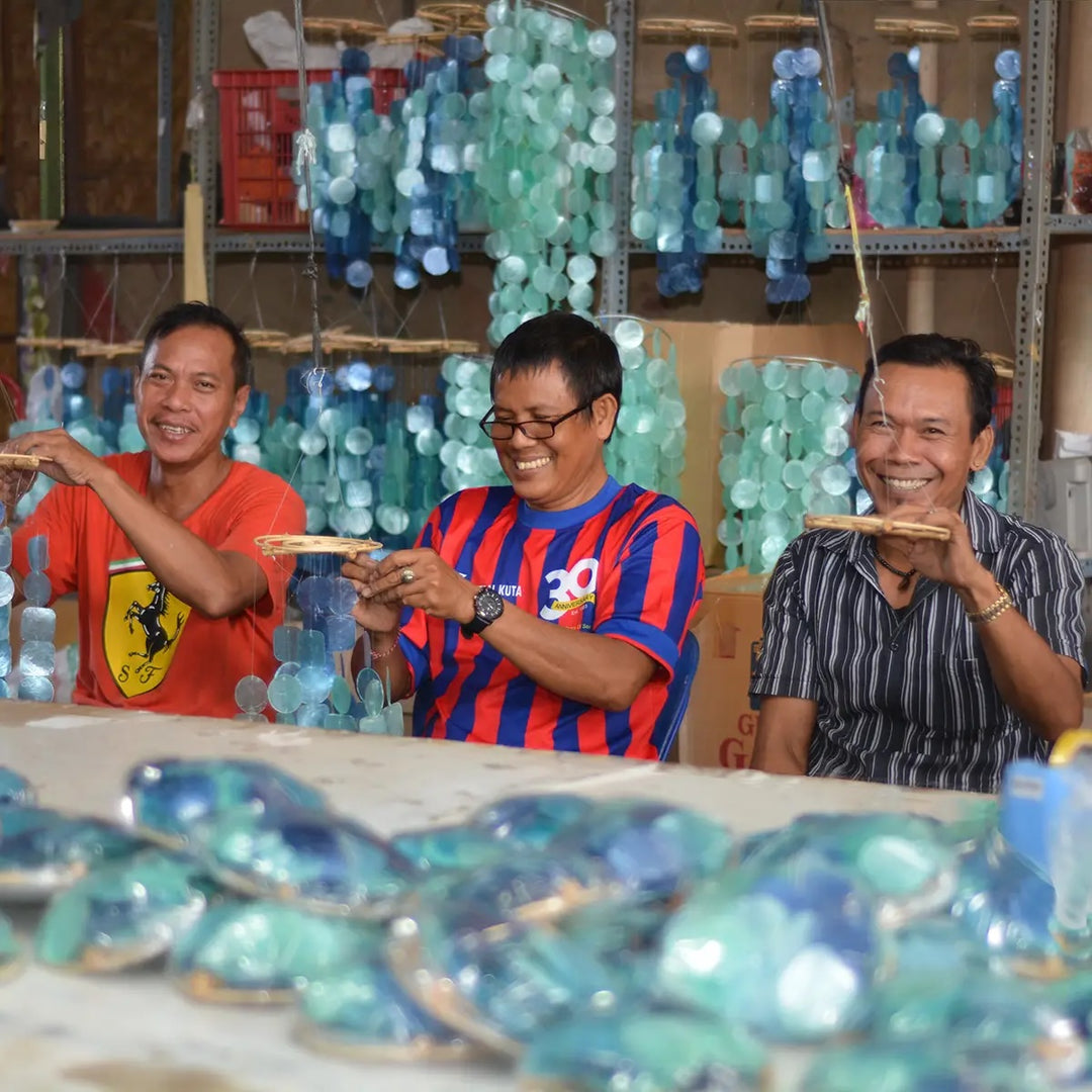 3 smiling Balinese men making wind chimes